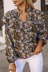 a woman wearing a floral blouse and white pants