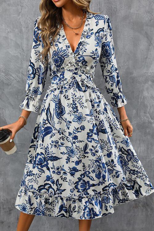 a woman in a blue and white floral print dress