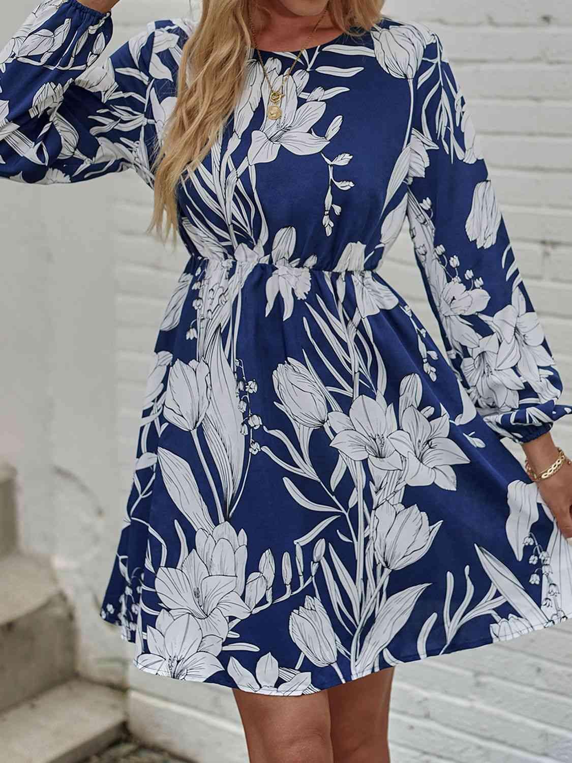 a woman wearing a blue and white floral print dress