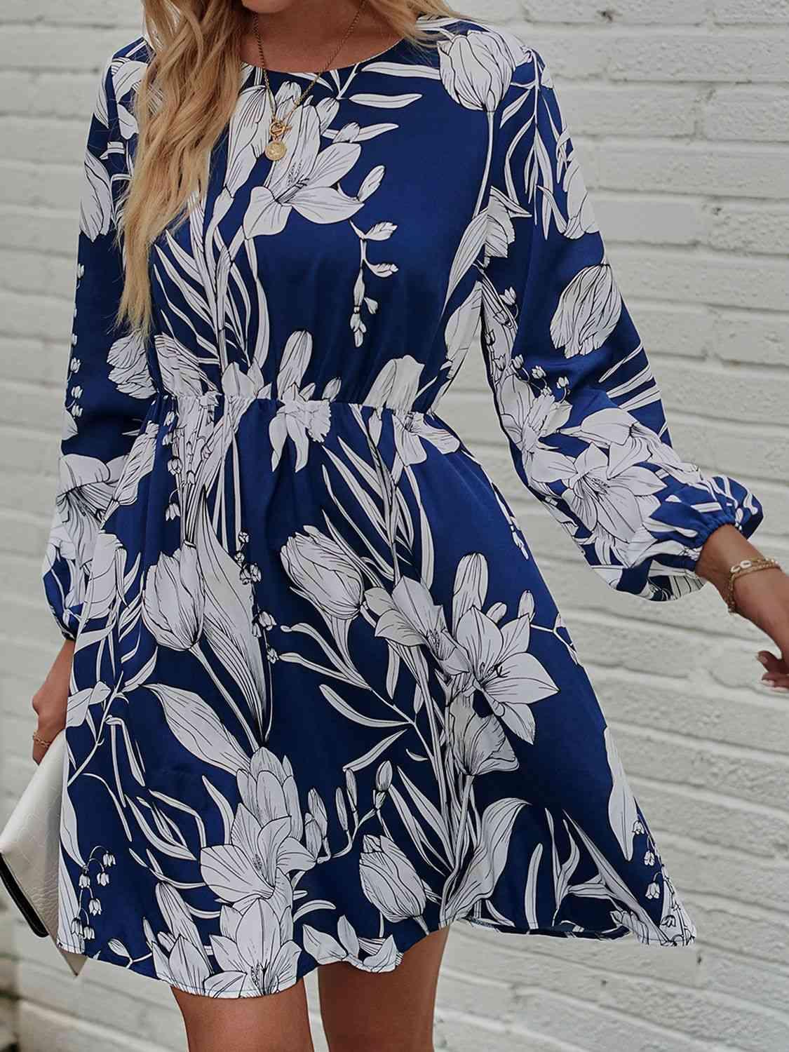 a woman wearing a blue and white floral print dress