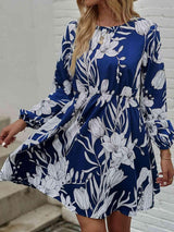 a woman wearing a blue and white floral print dress