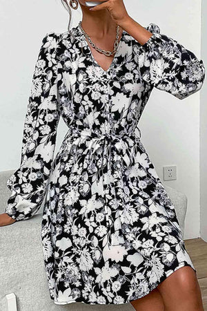 a woman wearing a black and white floral dress