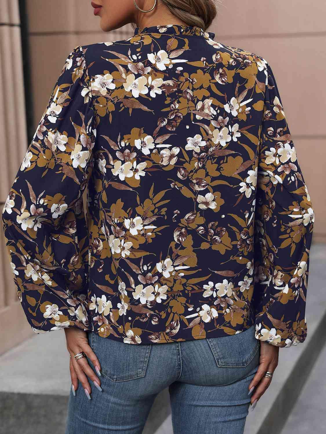 a woman wearing a floral blouse and jeans