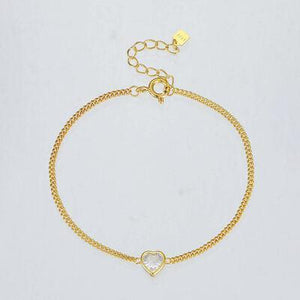 a gold bracelet with a heart charm