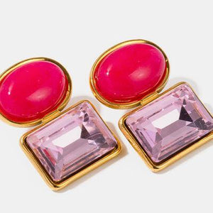 a pair of pink and gold earrings on a white background