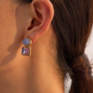 a close up of a person wearing a pair of earrings