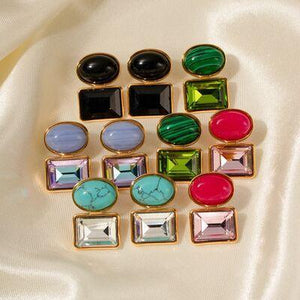 a bunch of different colored stones sitting on top of a white cloth