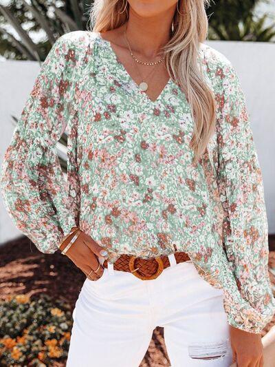 a woman wearing a floral blouse and white jeans