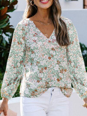 a woman wearing a floral blouse and white jeans