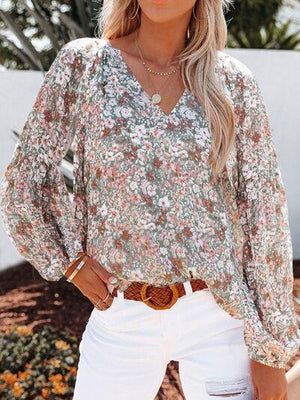 a woman wearing a floral blouse and white jeans