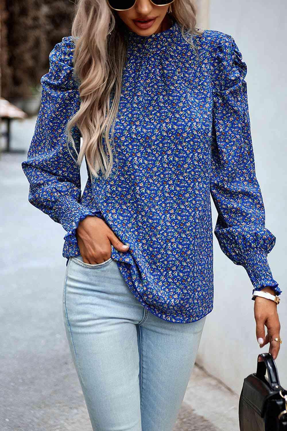 a woman wearing a blue blouse and jeans