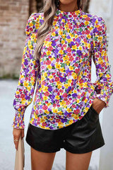 a woman wearing a colorful shirt and black shorts