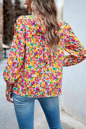 a woman wearing a colorful blouse and jeans