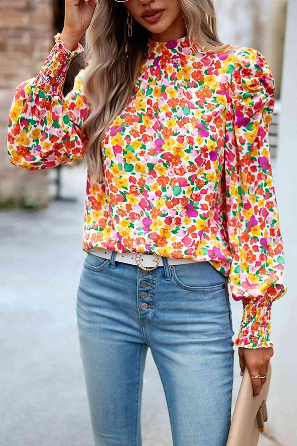 a woman wearing a floral blouse and jeans