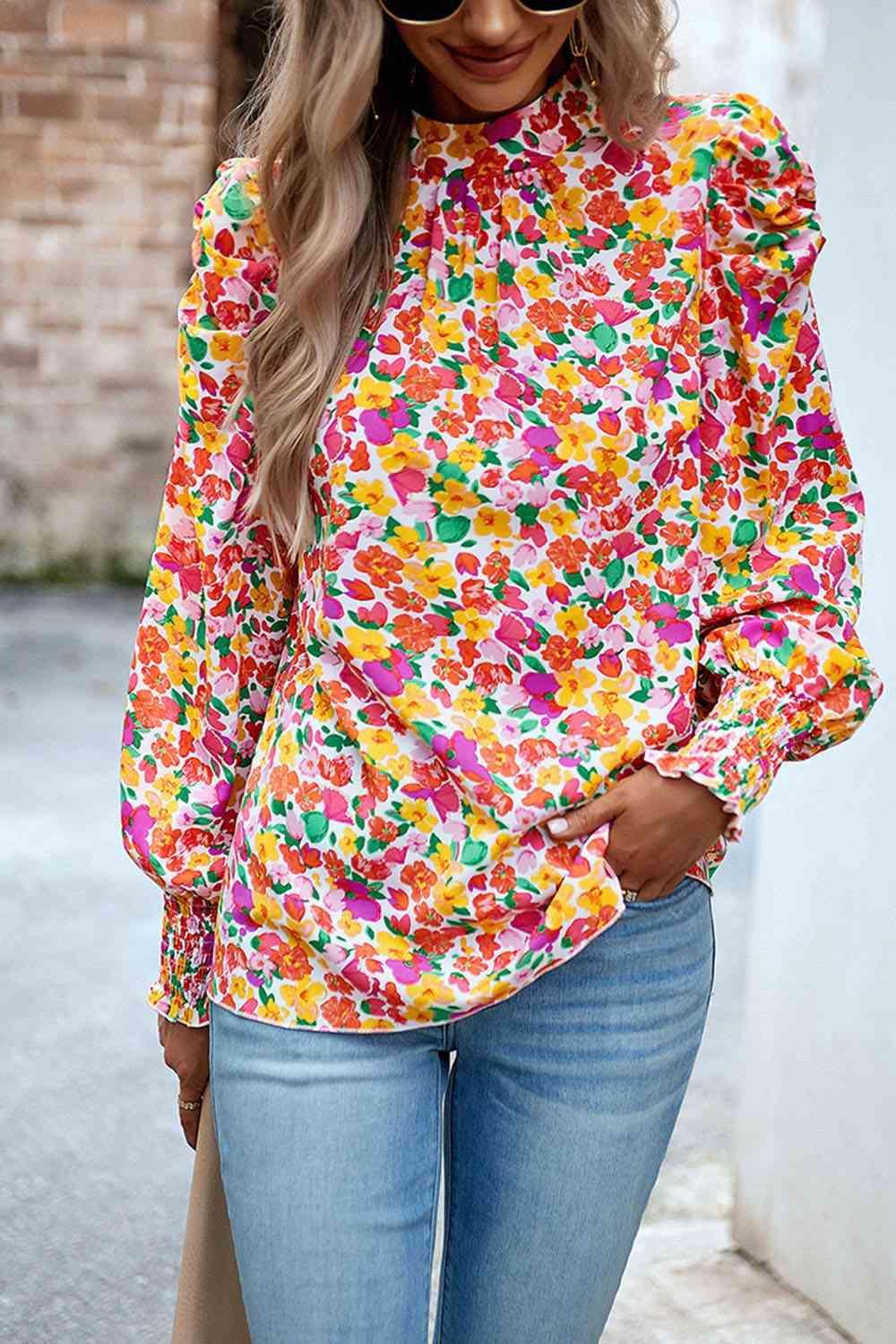 a woman wearing a colorful blouse and jeans