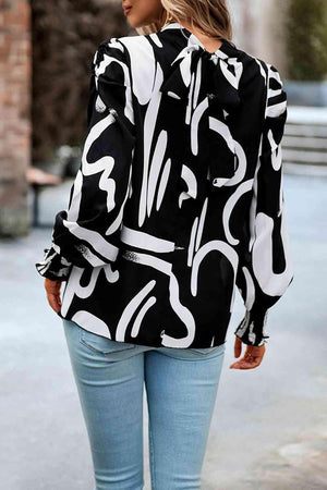 a woman walking down a street wearing a black and white shirt