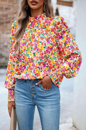 a woman wearing a colorful blouse and jeans