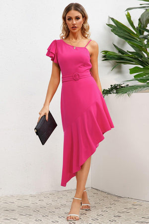 a woman in a pink dress holding a black purse