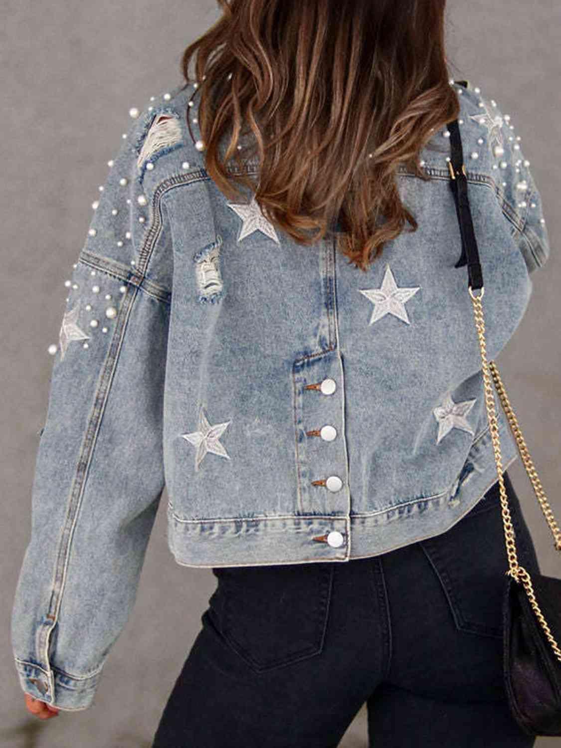 a woman wearing a jean jacket with stars on it