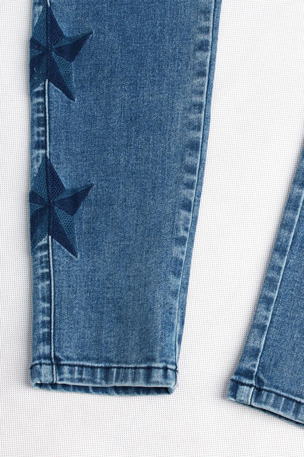 a pair of blue jeans with bows on them