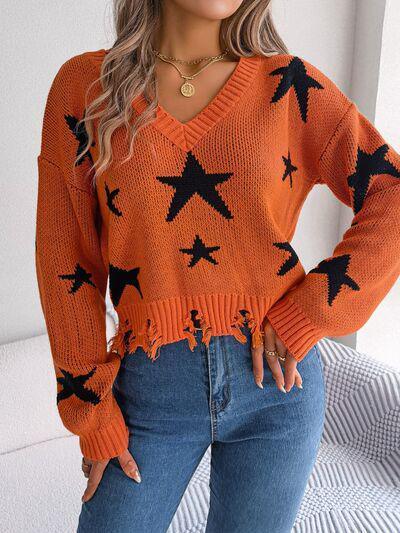 a woman wearing an orange sweater with black stars on it