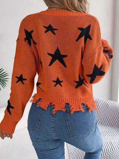 a woman wearing an orange sweater with black stars on it