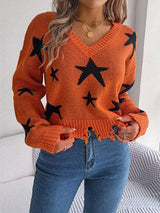 a woman wearing an orange sweater with black stars on it