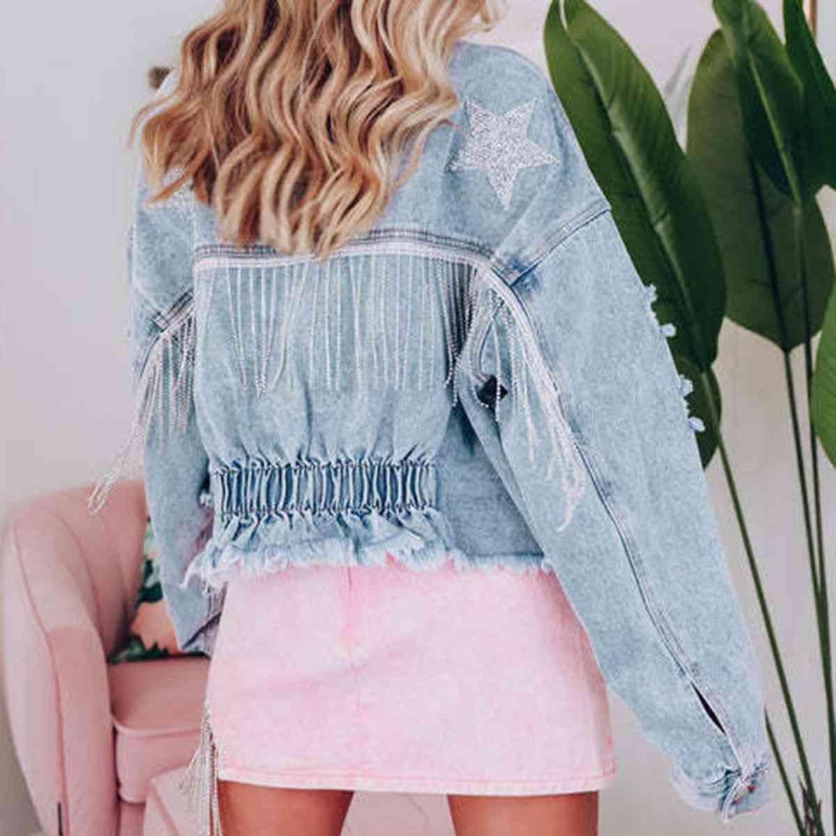 a woman wearing a denim jacket and pink skirt