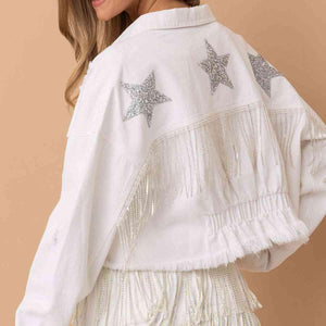 a woman wearing a white jacket with silver stars on it