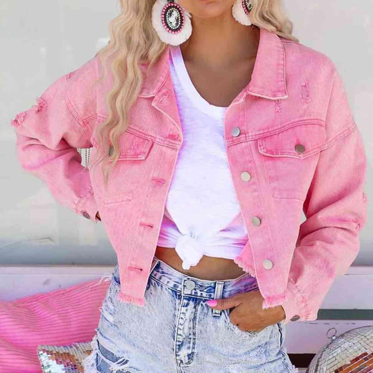 a woman wearing a pink jean jacket and denim shorts