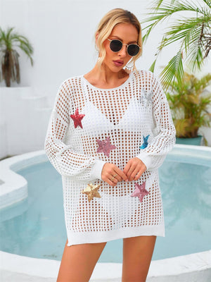 a woman standing next to a pool wearing a white crochet dress