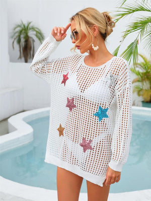 a woman standing next to a pool wearing a white sweater