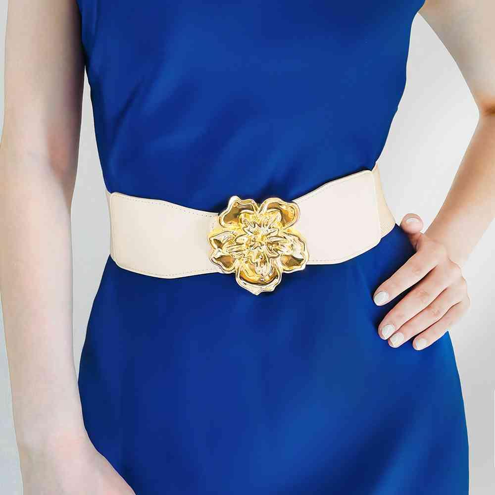 a woman wearing a blue dress with a gold flower belt
