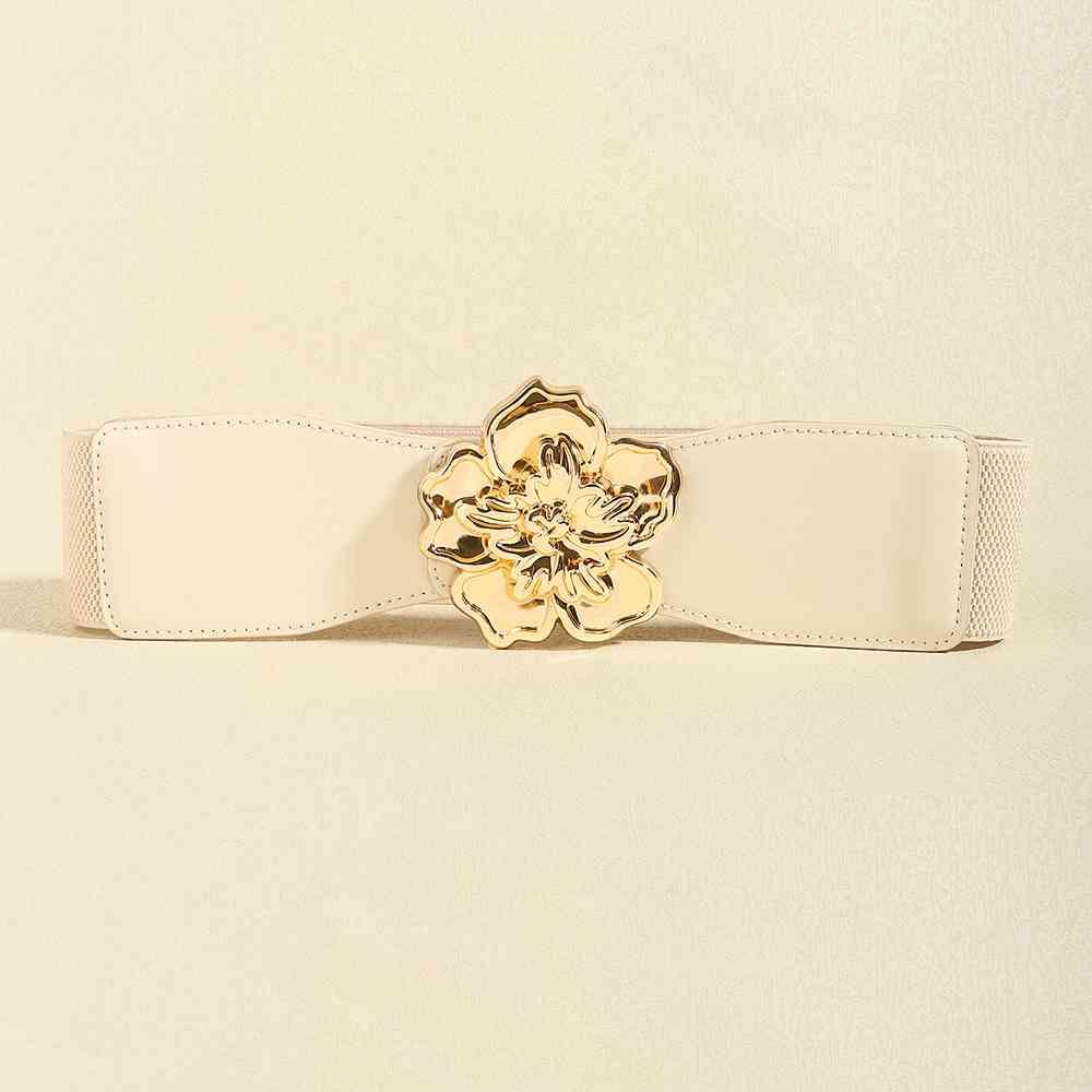 a white belt with a gold flower buckle