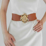 a woman wearing a white dress and a brown belt