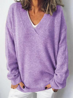 a woman wearing a purple sweater and white jeans