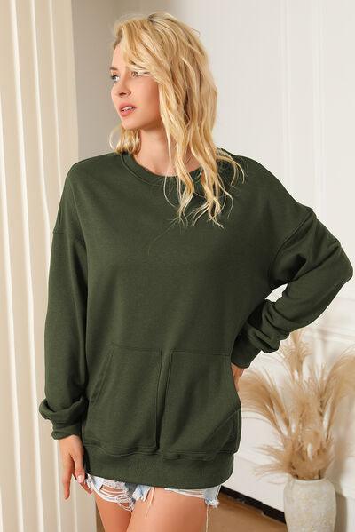 a woman wearing a green sweatshirt and ripped shorts