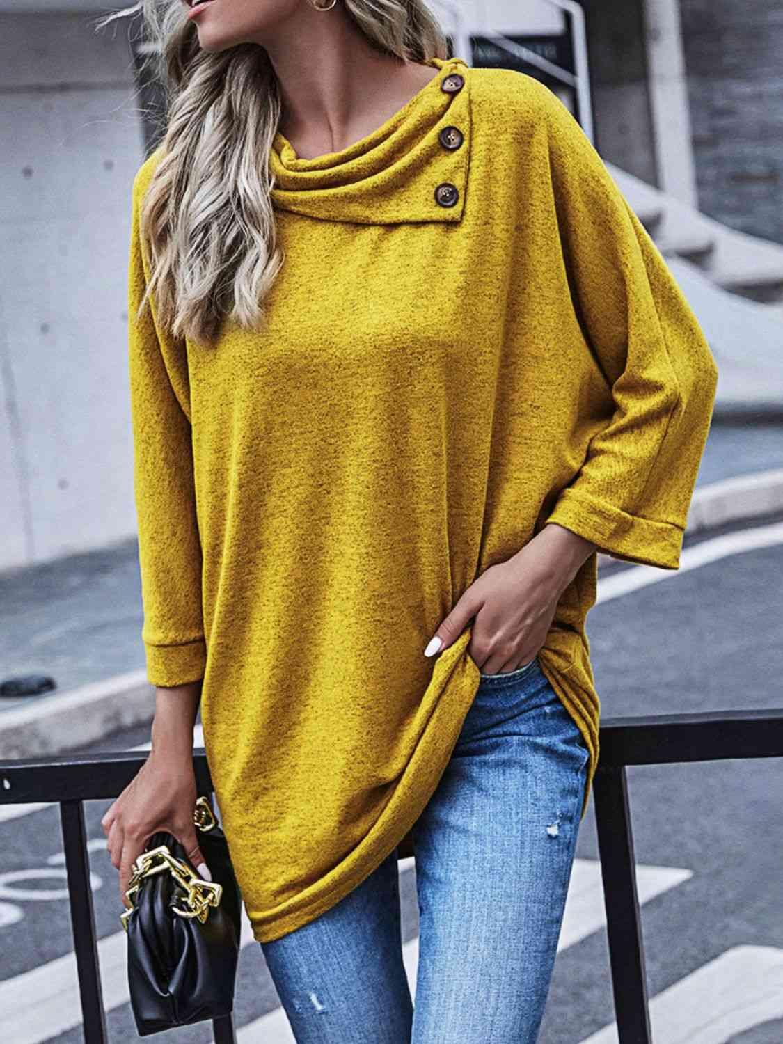 a woman wearing a yellow sweater and jeans