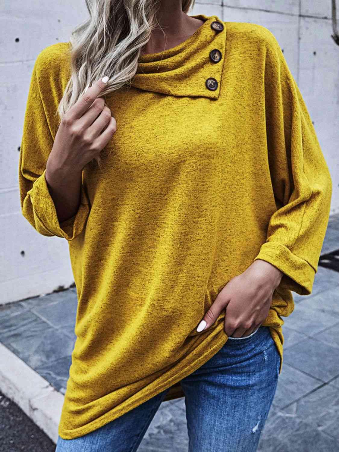 a woman wearing a yellow sweater and jeans