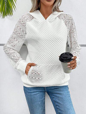 a woman in a white sweater holding a coffee cup