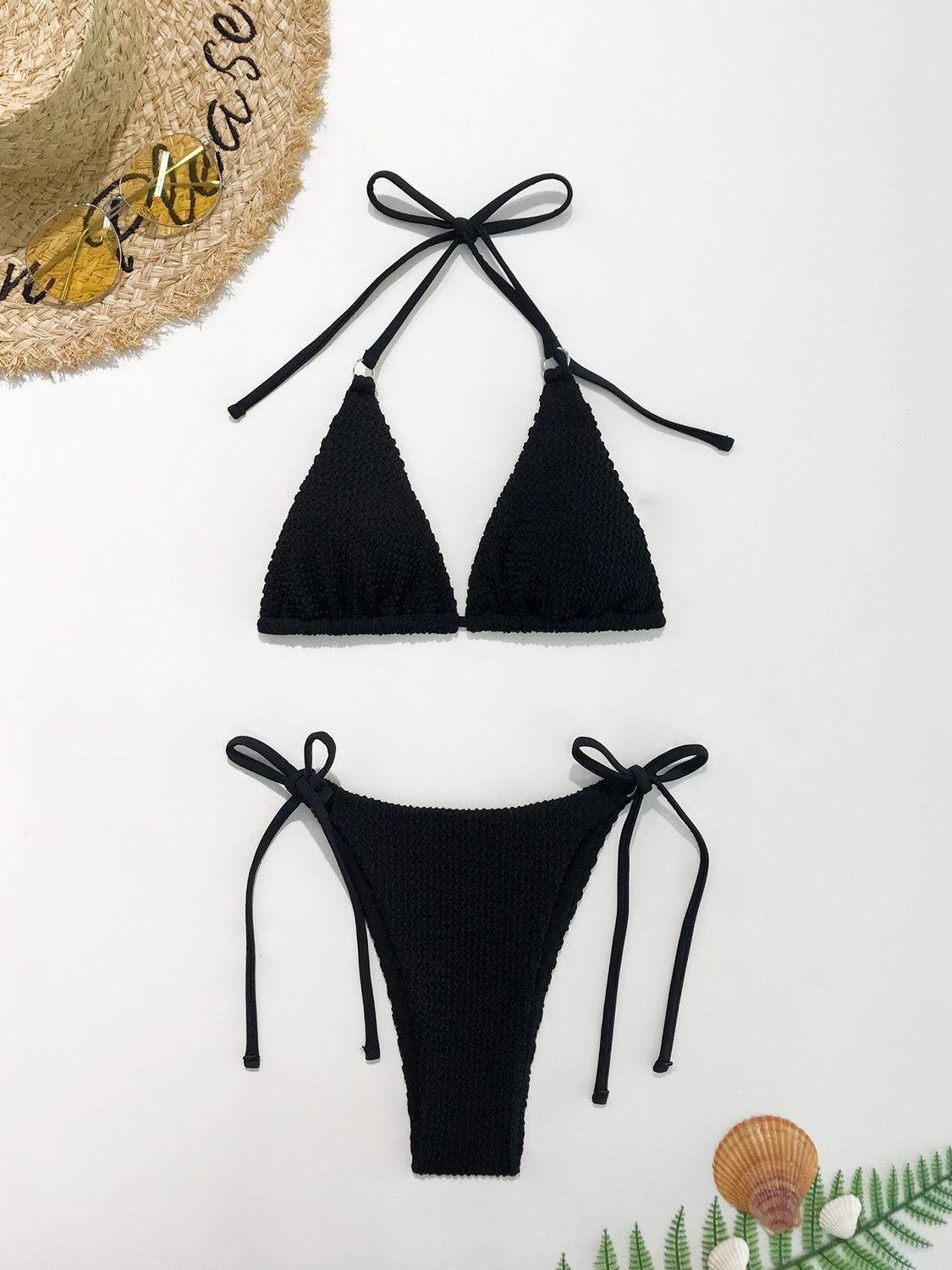 two pieces of black bikinisuit with a straw hat on top of it