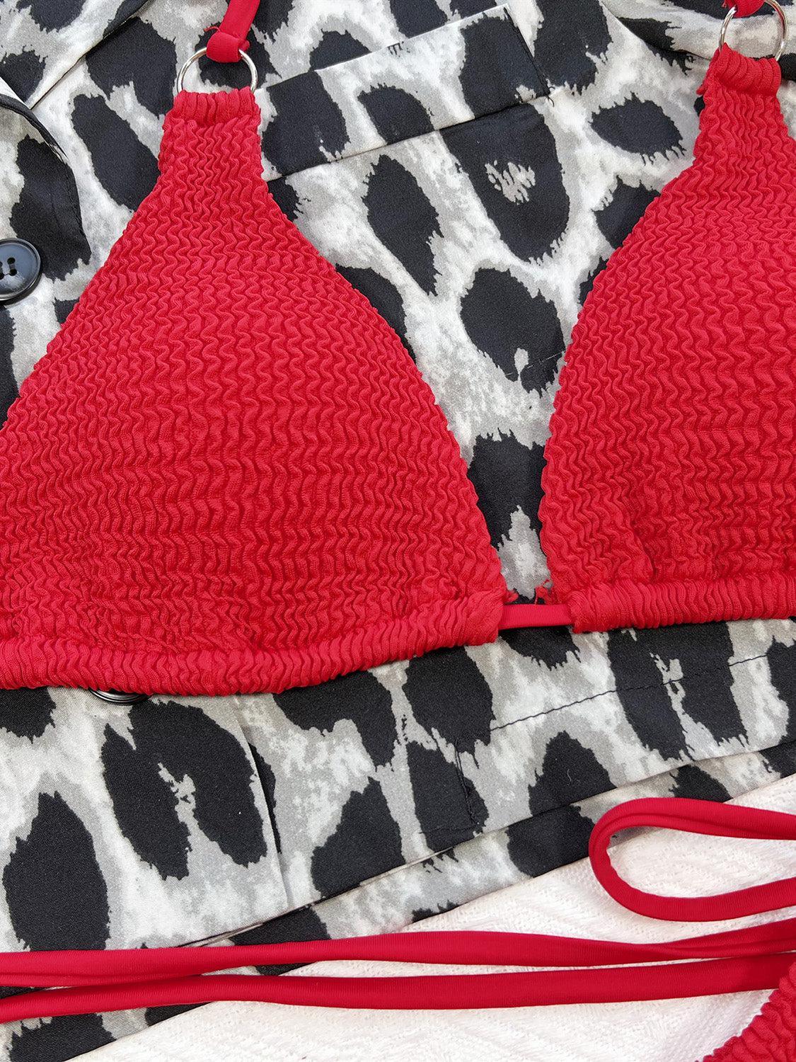 a red bikini top laying on top of a black and white pattern