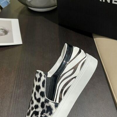 a pair of zebra print shoes on a table