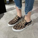 a woman wearing leopard print slip on shoes