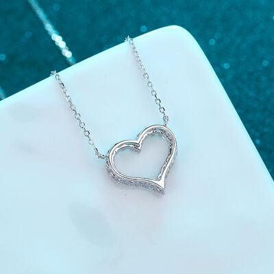 a heart shaped necklace sitting on top of a white plate