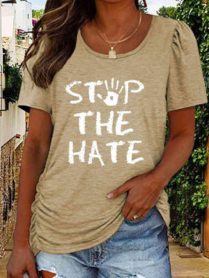 a woman wearing a t - shirt that says stop the hate