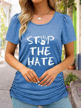 a woman wearing a blue shirt that says stop the hate