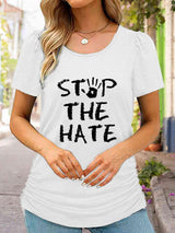 a woman wearing a white shirt that says stop the hate