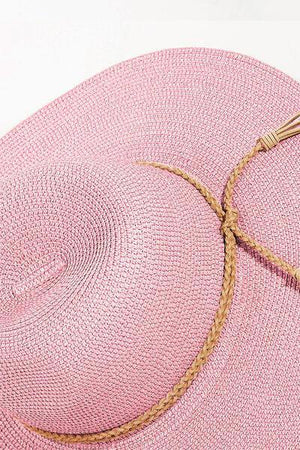 a pink hat with a tassel on top of it