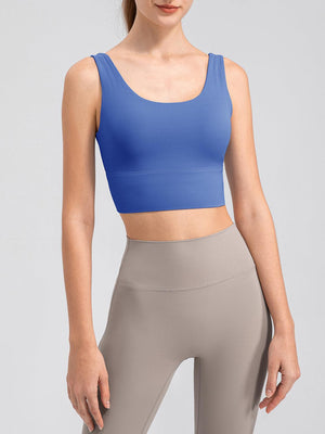 a woman wearing a blue crop top and grey leggings